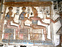 Фараон Рамсес III (Новое царство, XX династия, ок. 1182-1151 гг. до н.э.) получает благословение Атума, Иусат и Небетхетепет.  Рельеф храма Мединет-Абу (западный берег Нила, Луксор).