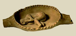 Модель лодки (?) и статуэтка спящего (умершего?) человека. Глина. Длина 25 см. Ок. 4000  лет до. н.э. Период Нагада I. Лейденский музей